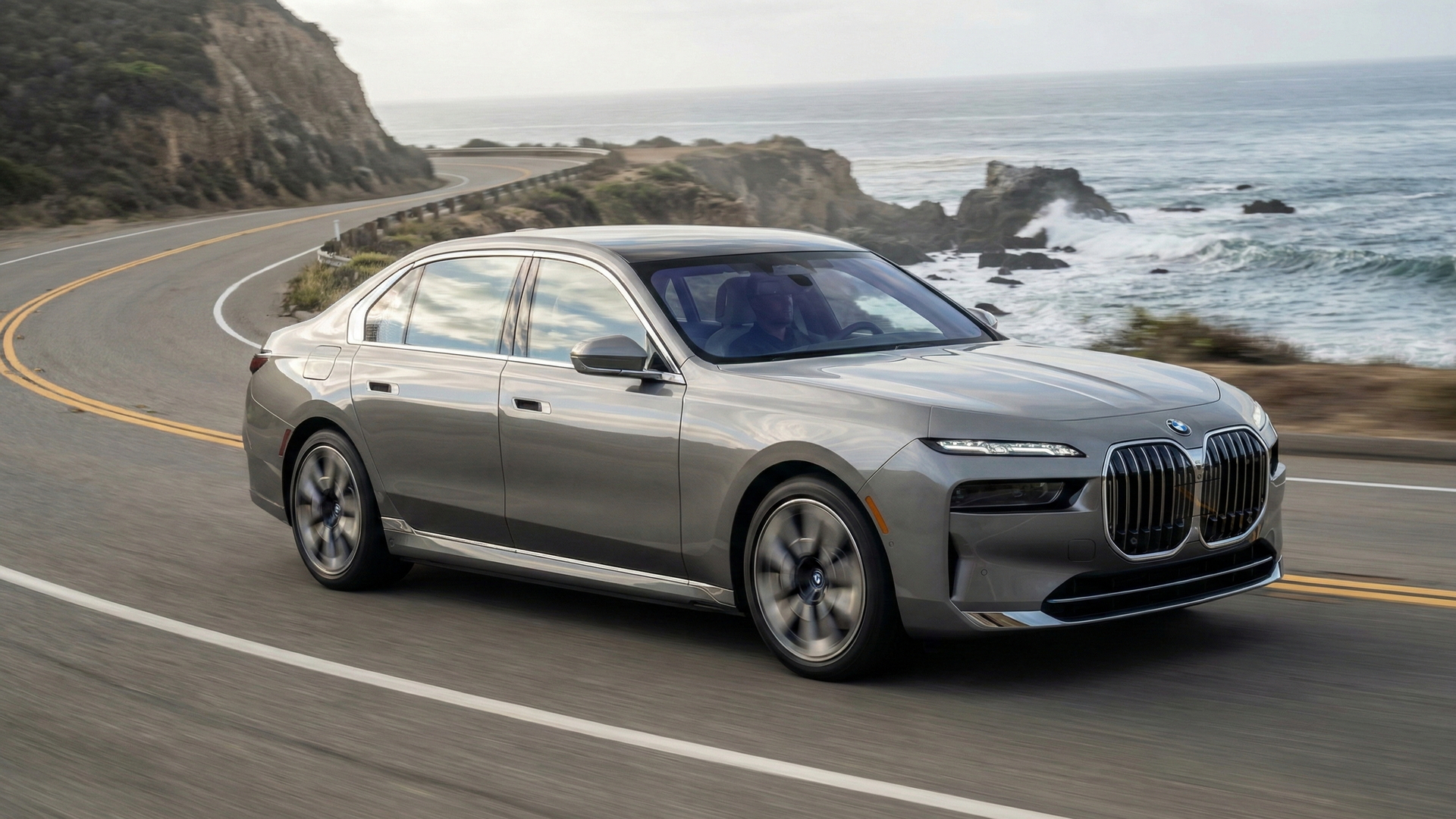 BMW i7 silver luxury sedan driving along a California coastal highway, ideal for owners ready to sell their car.