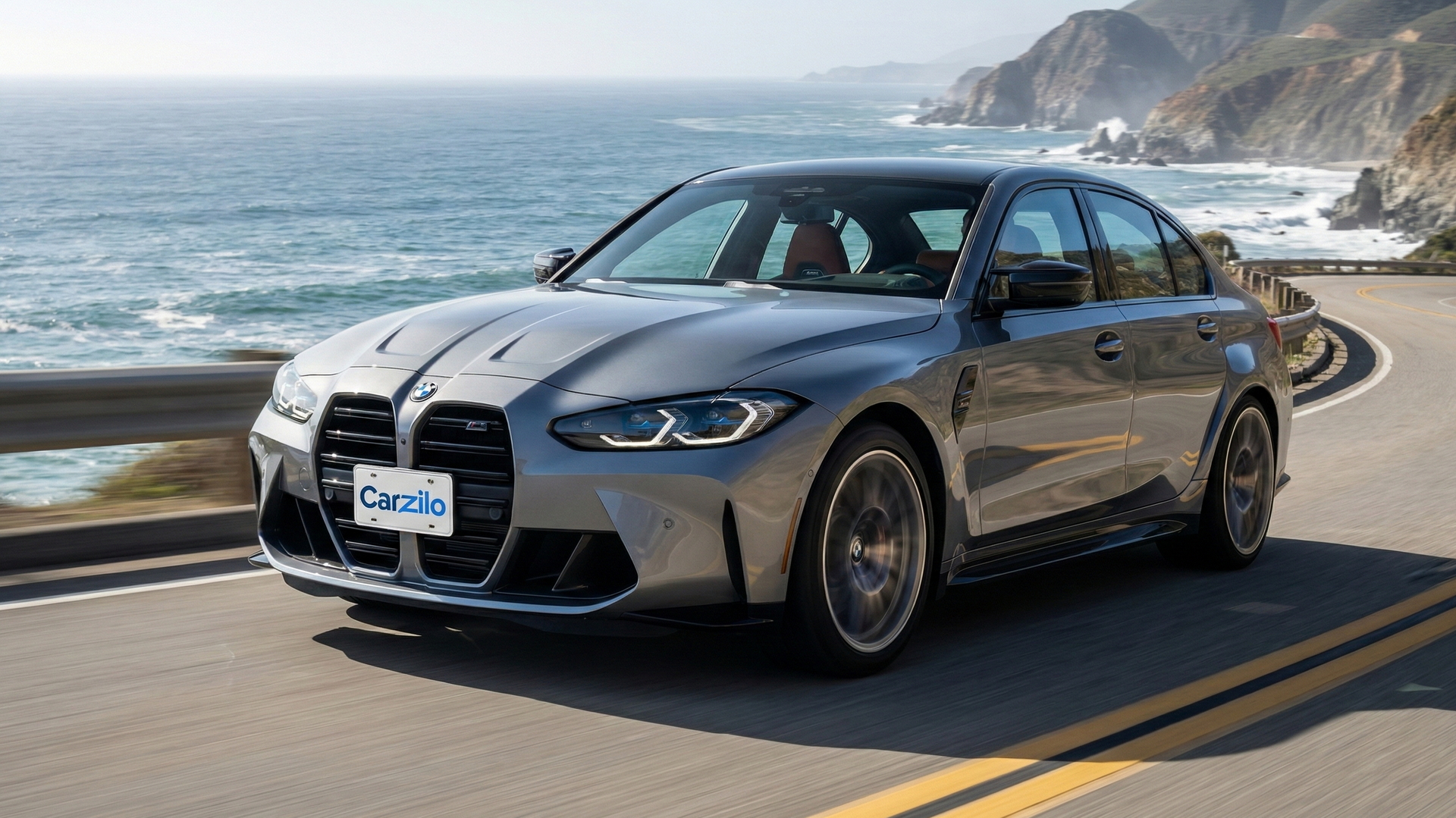 BMW M3 gray sports sedan driving along a winding California coastal highway, ideal for owners ready to sell their car.