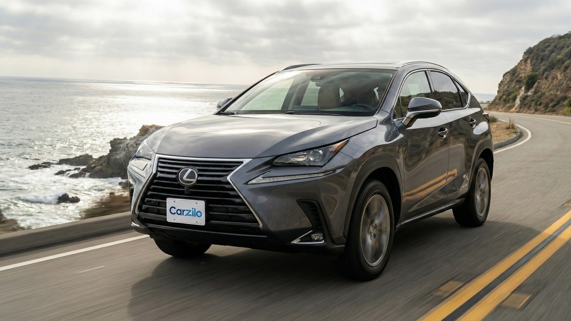 Sell Your Lexus NX on the California Coast Lexus NX gray SUV driving along a winding California coastal highway, ideal for owners ready to sell their car.