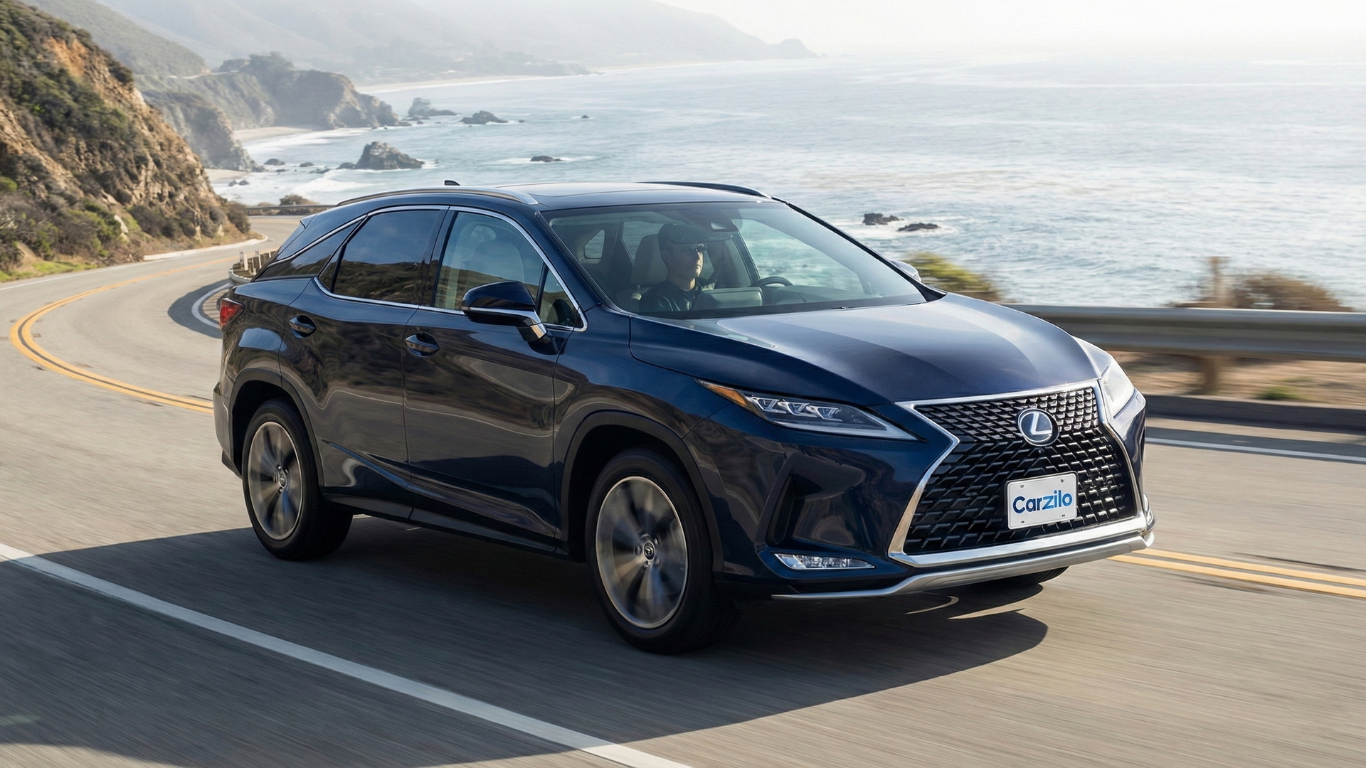 California Buyers for Your LEXUS RX LEXUS RX blue SUV driving along a scenic California coastal highway, perfect for owners preparing to sell their car.