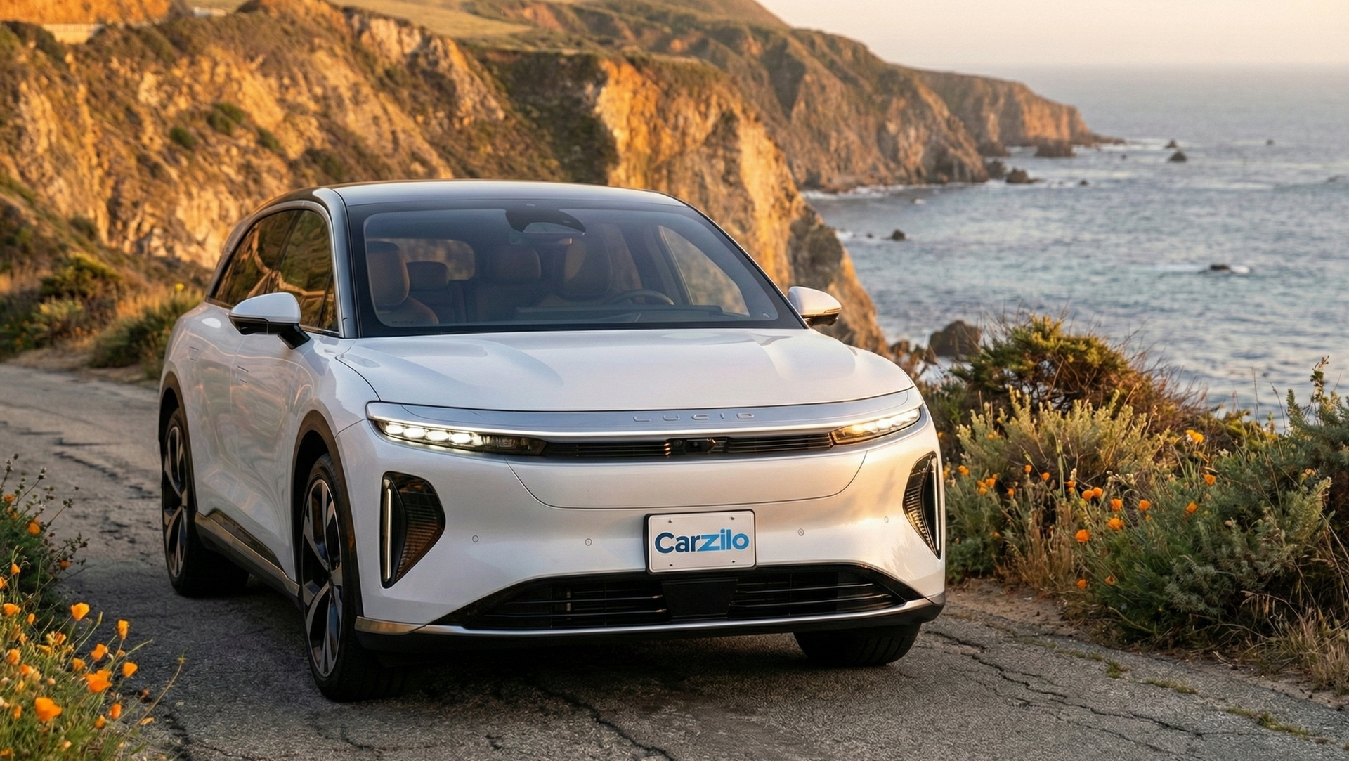 Sell Your Lucid Gravity on the California Coast Lucid Gravity white electric SUV driving along a scenic California coastal cliff road, perfect for owners ready to sell their car.