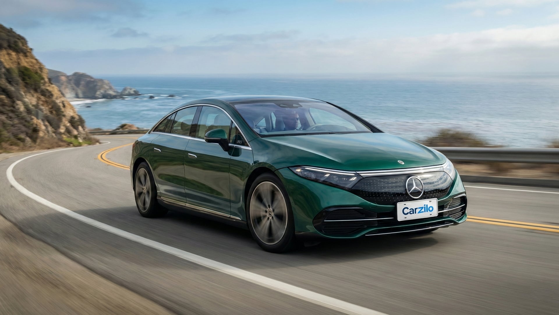 Sell Your Mercedes-Benz AMGS Sedan in California Mercedes-Benz AMGS Sedan in green driving on a coastal California highway, ideal for owners ready to sell their electric luxury car.